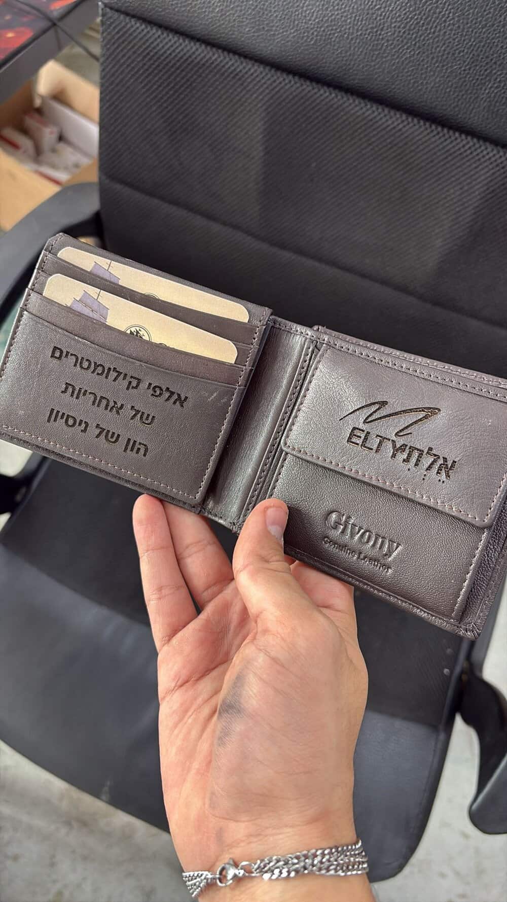 ארנק חום עם חריטה פנימית לוגו בצד אחד ומשפט בצד שני