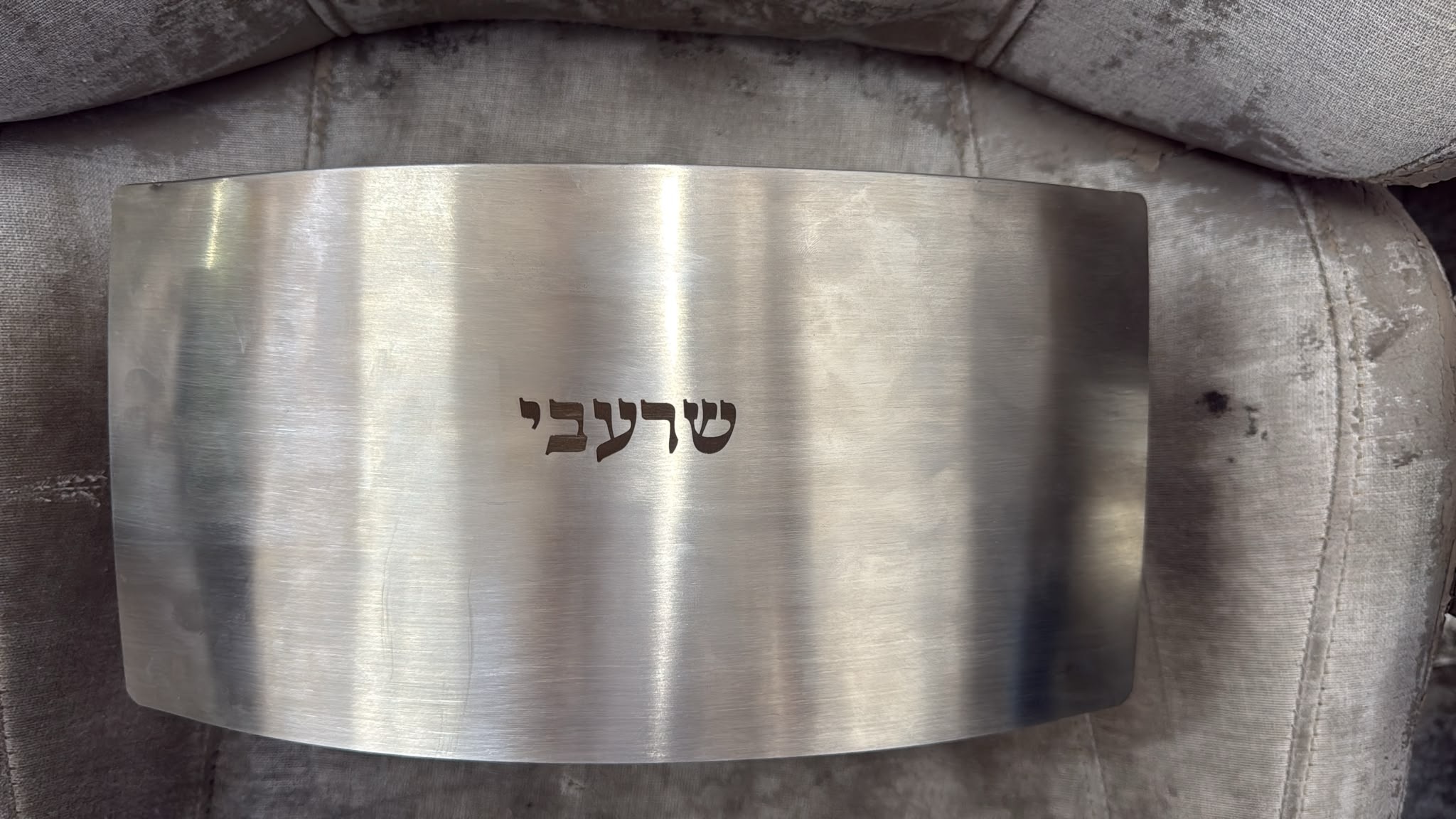 חריטה על גב ארון נר נשמה מנירוסטה עם שם משפחת שרעבי