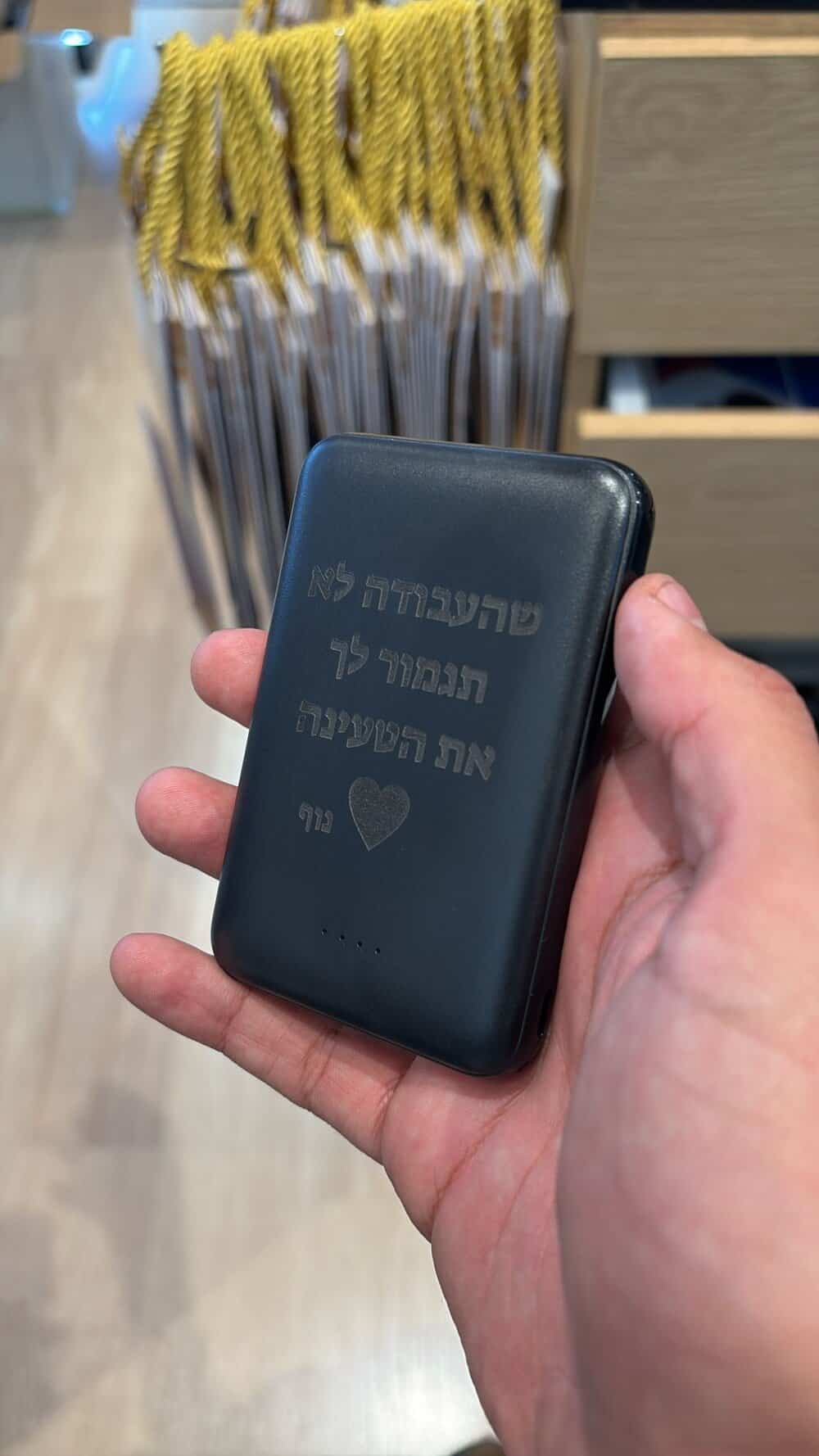 חריטה על מטען נייד שחור בעברית