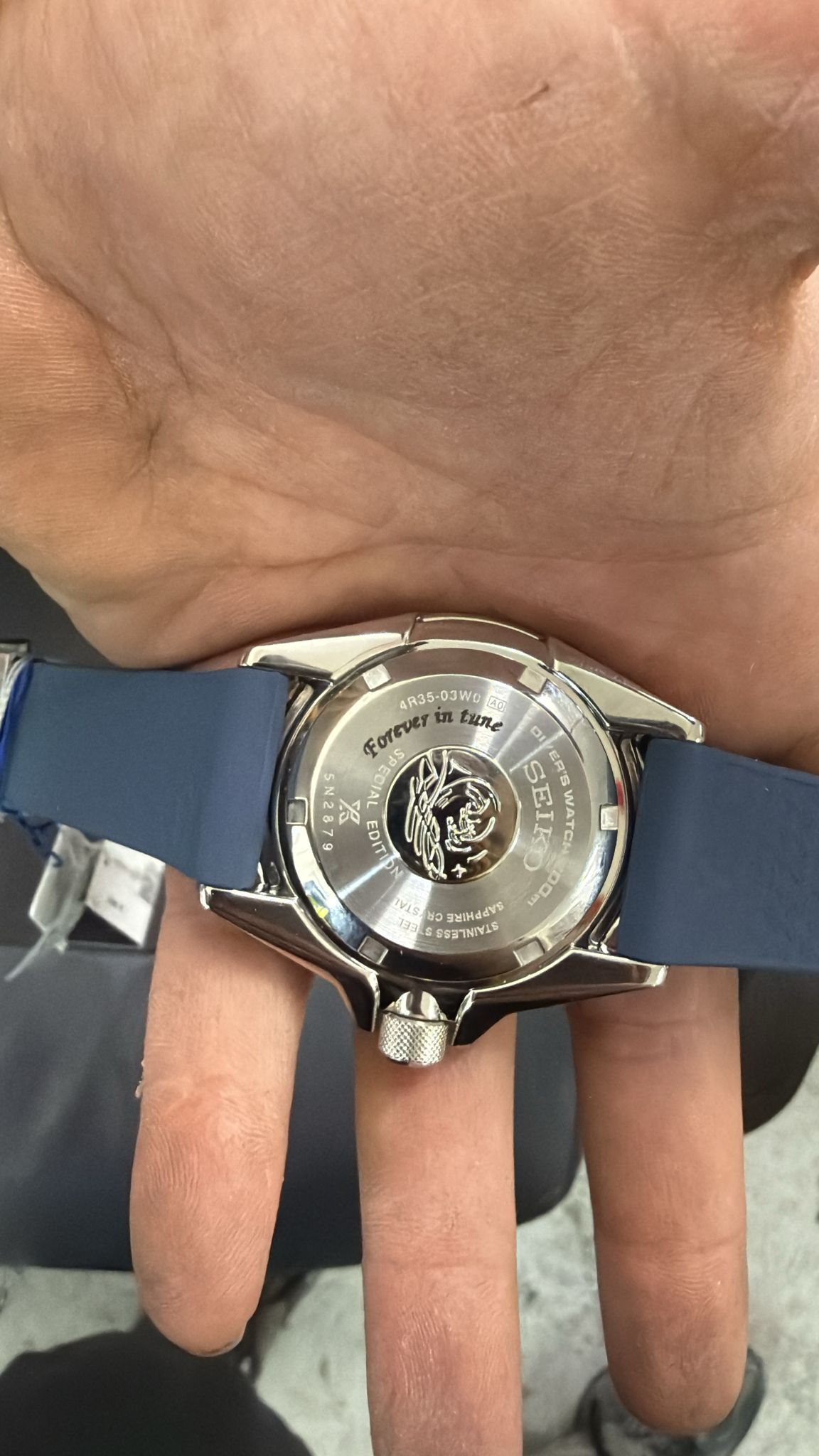 חריטה על מכסה אחורי שעון Seiko נירוסטה עם כיתוב Forever in tune ולוגו