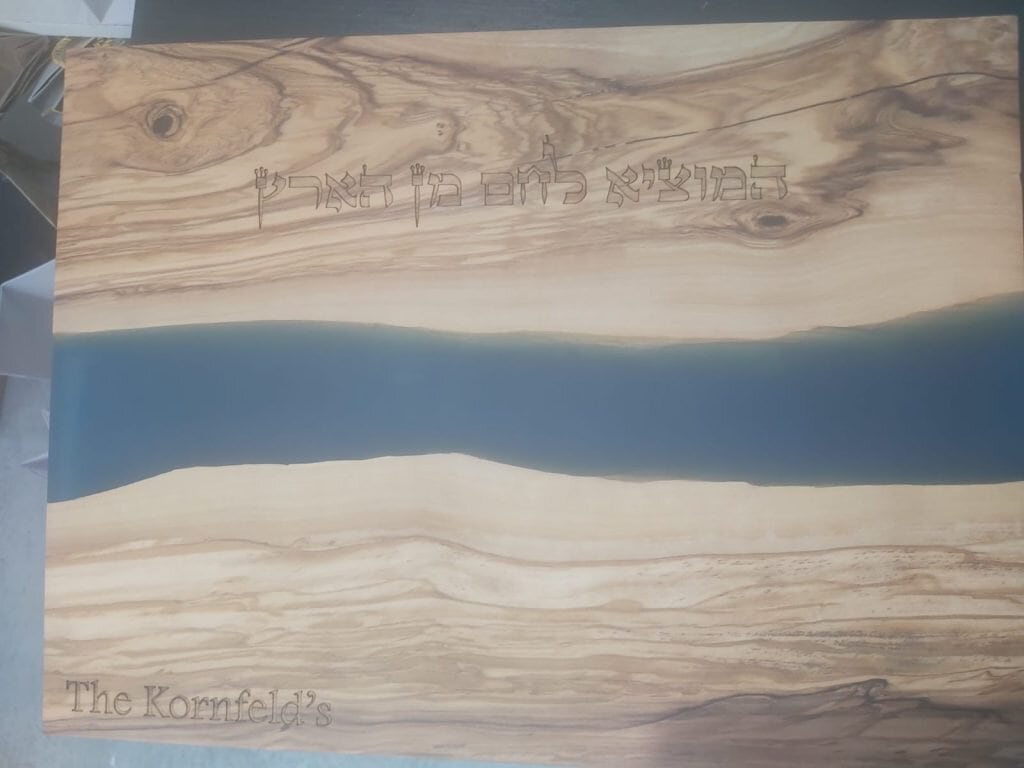חריטה על קרש עץ גדול המוציא לחם מן הארץ