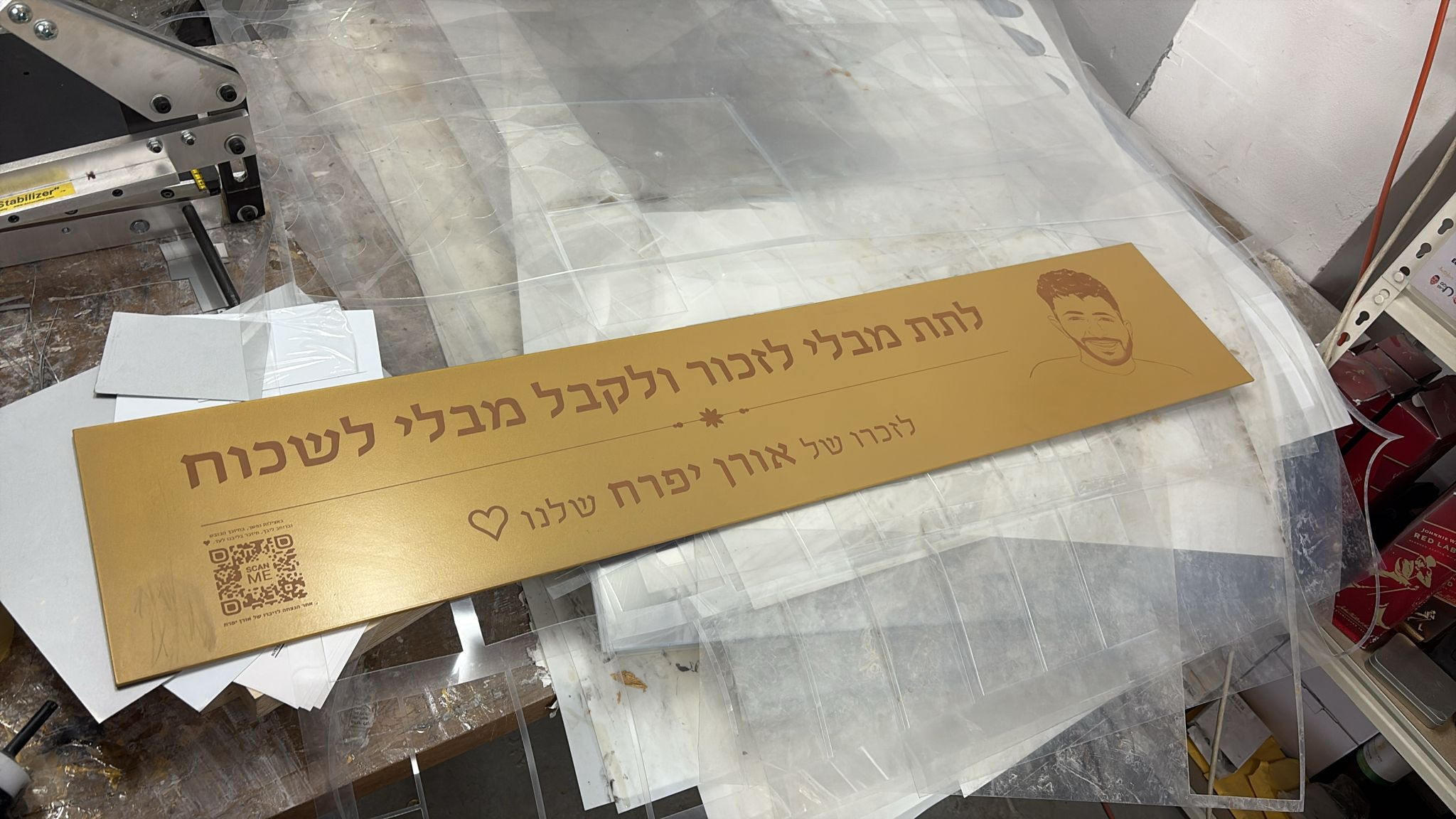 חריטה על שלט אלומיניום צבוע זהוב הנצחה לזכרו של אורן יפרח עם דיוקן וקוד QR