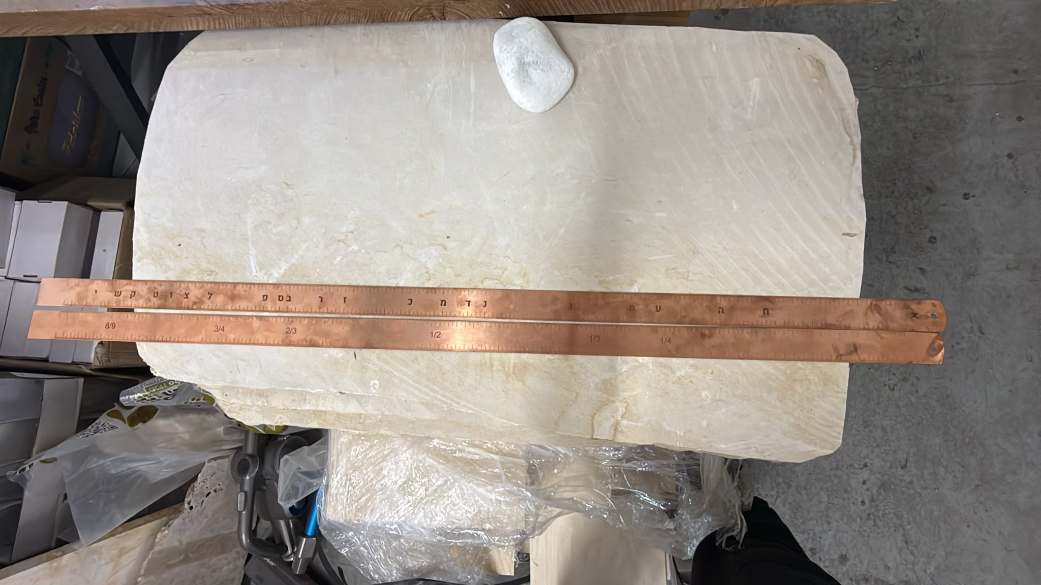 חריטה על שני פסי נחושת ארוכים עם סרגל שברים ואותיות עבריות