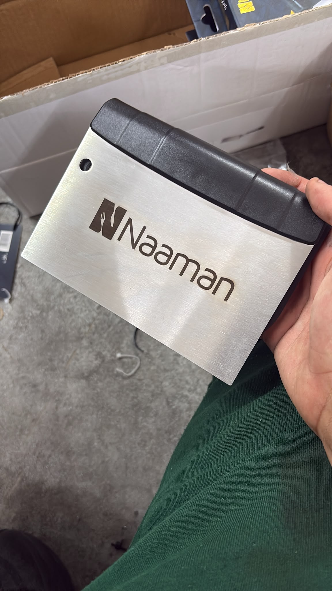 חריטה של הלוגו Naaman על מגרדת בצק מנירוסטה עם ידית שחורה