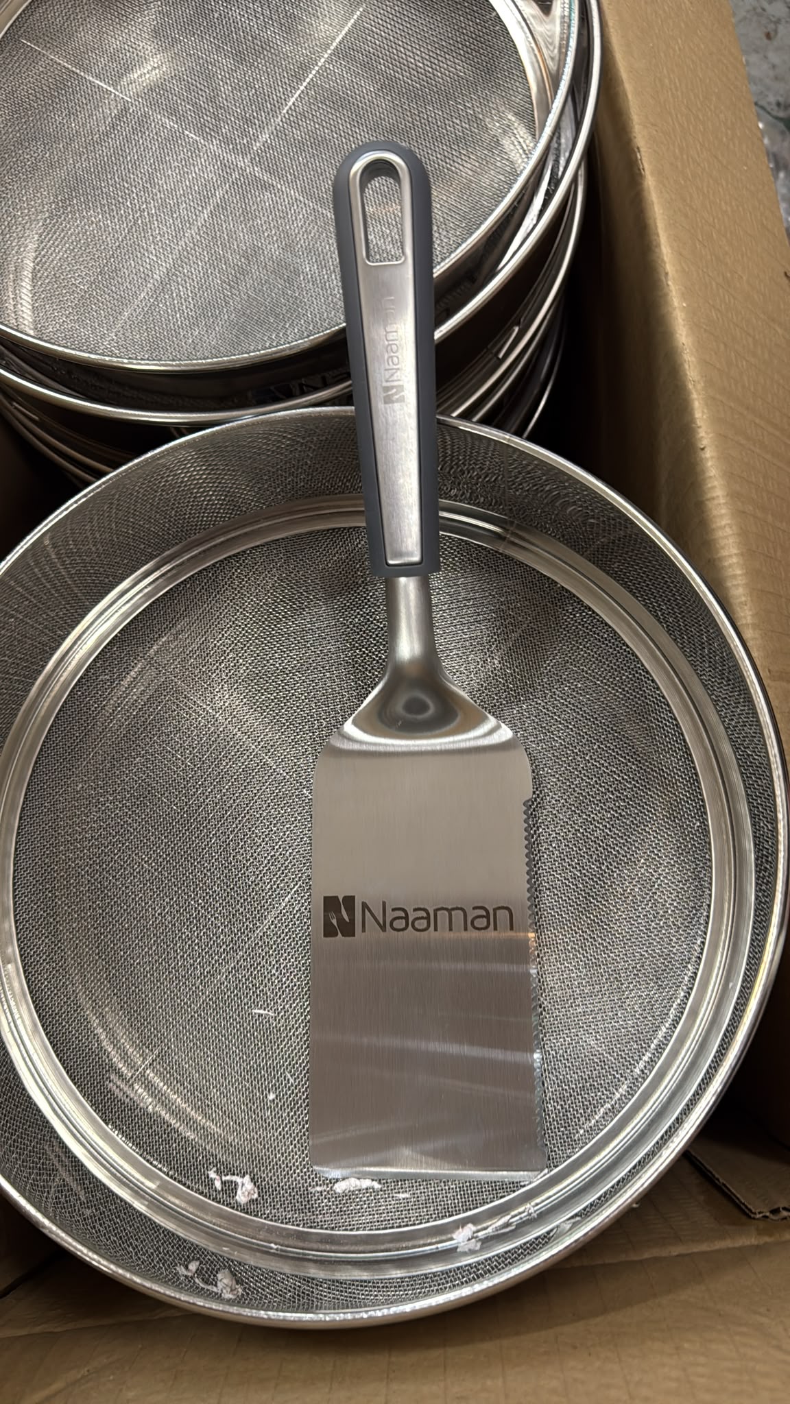 חריטה של הלוגו Naaman על מרית הגשה מנירוסטה עם להב משונן