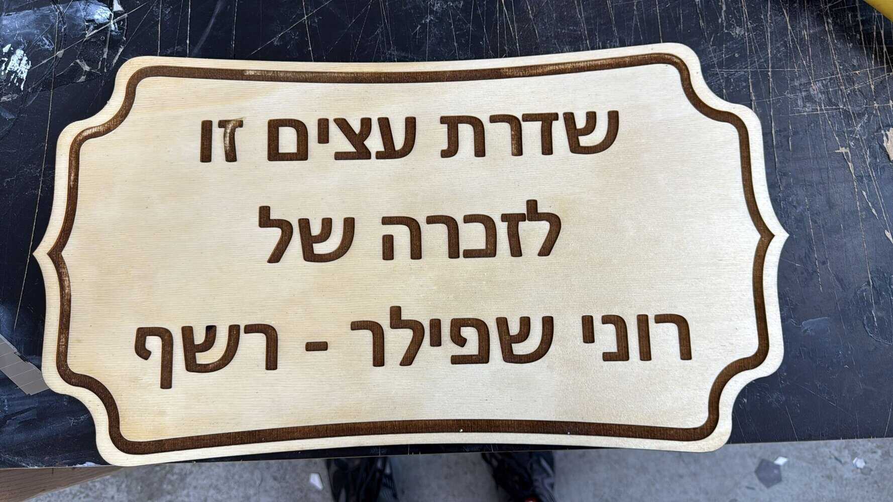 חריטה של שלט עץ לשדרת עצים להנצחה