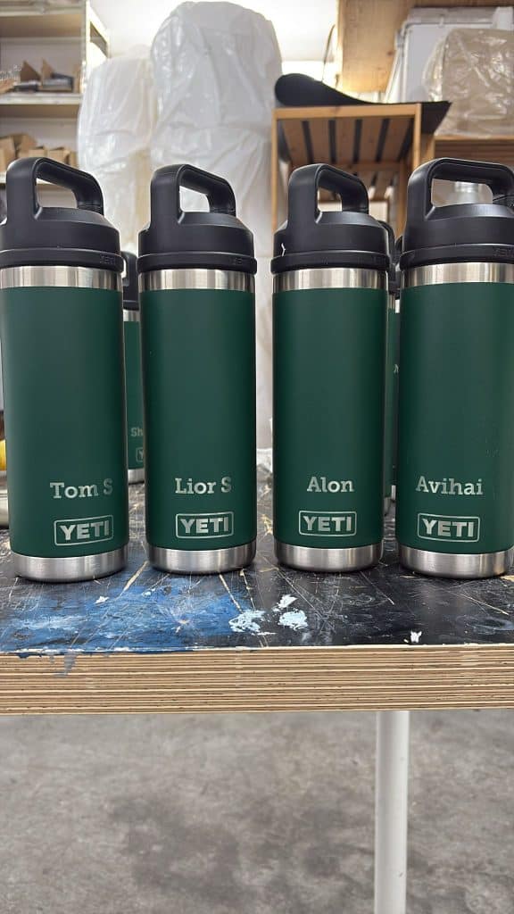 חריטה של שמות באנגלית על בקבוקים תרמיים ירוקים