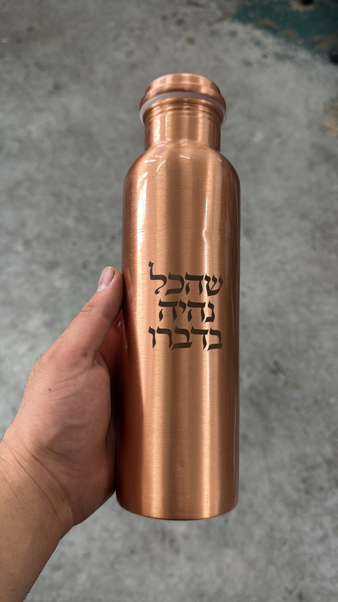 חריטת ברכת שהכל נהיה בדברו על בקבוק נחושת לשתיית מים