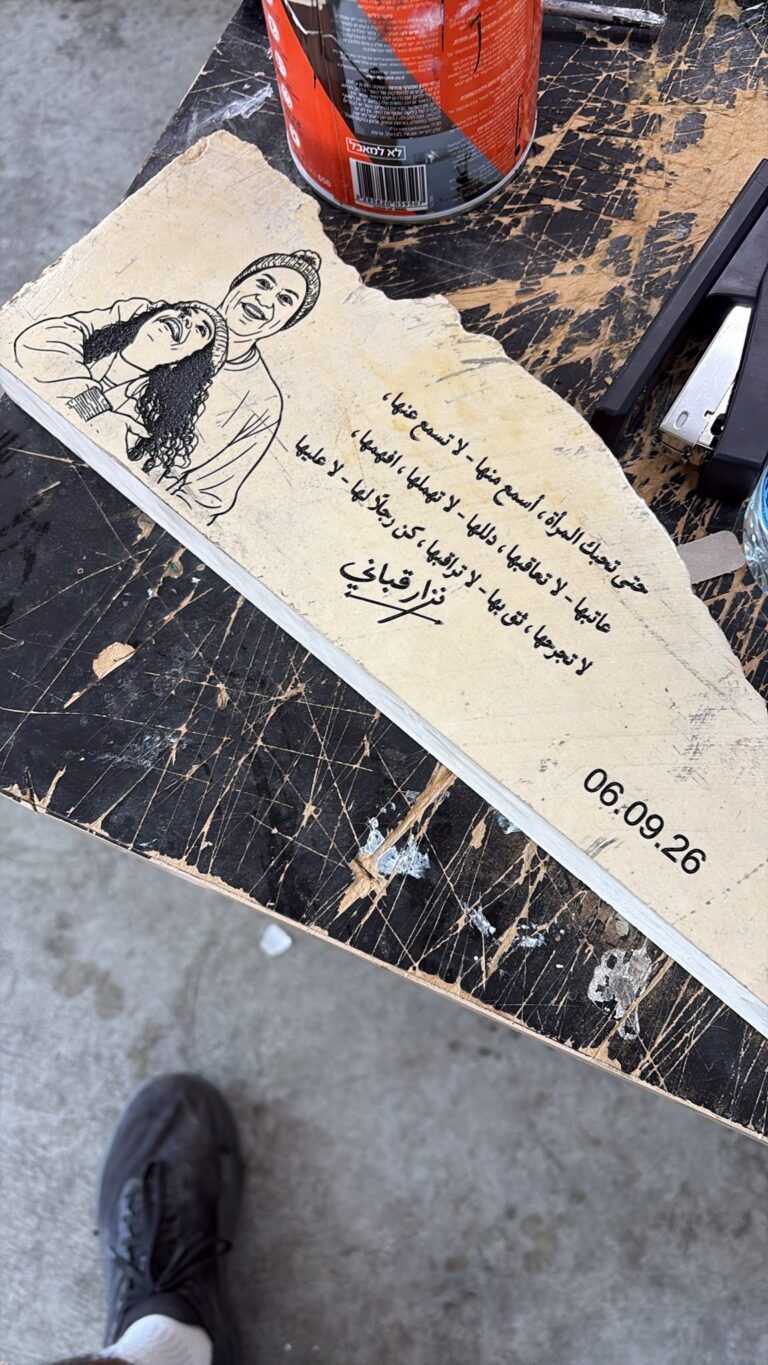 חריטה על אבן בצורת דף קרוע עם דיוקן זוג ושיר בערבית של נזאר קבאני