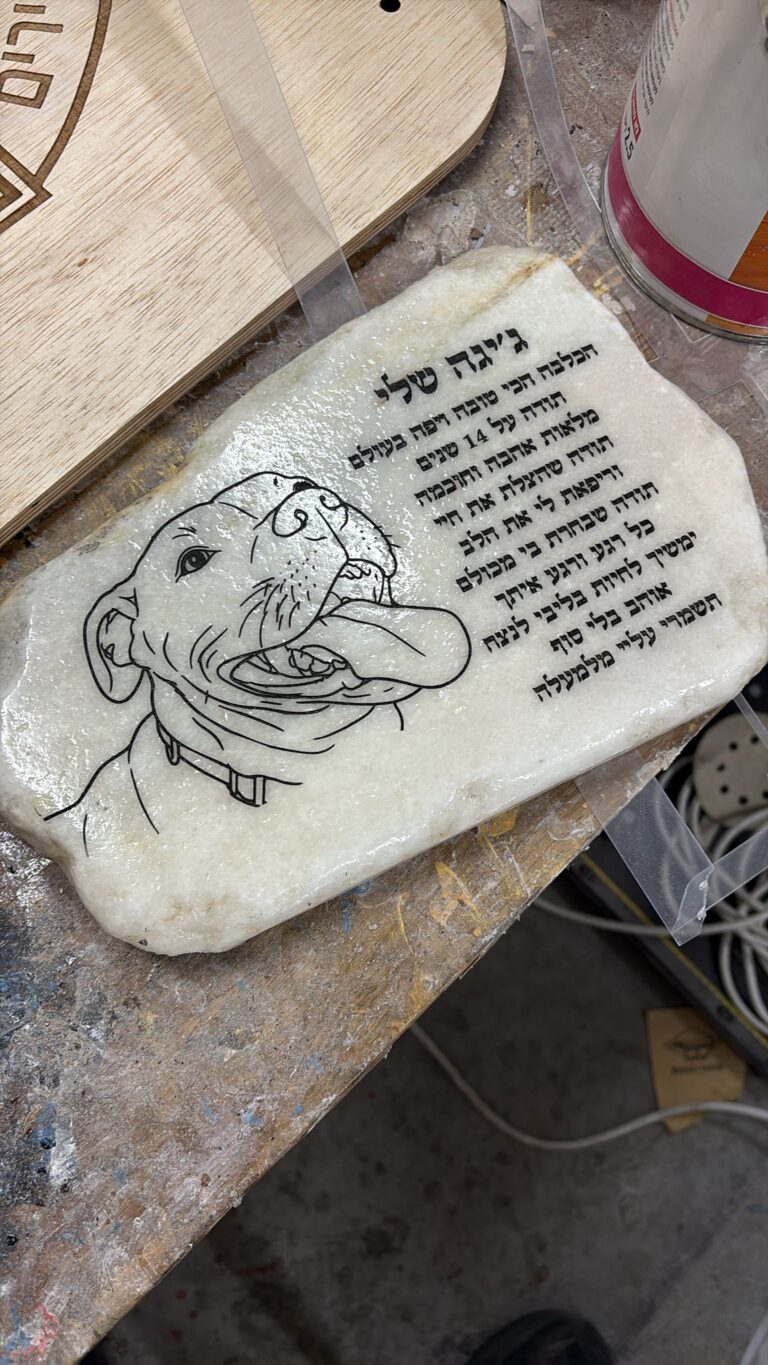 חריטה על אבן להנצחה משיש בהיר עם איור כלב וברכה לג'יזל סילו