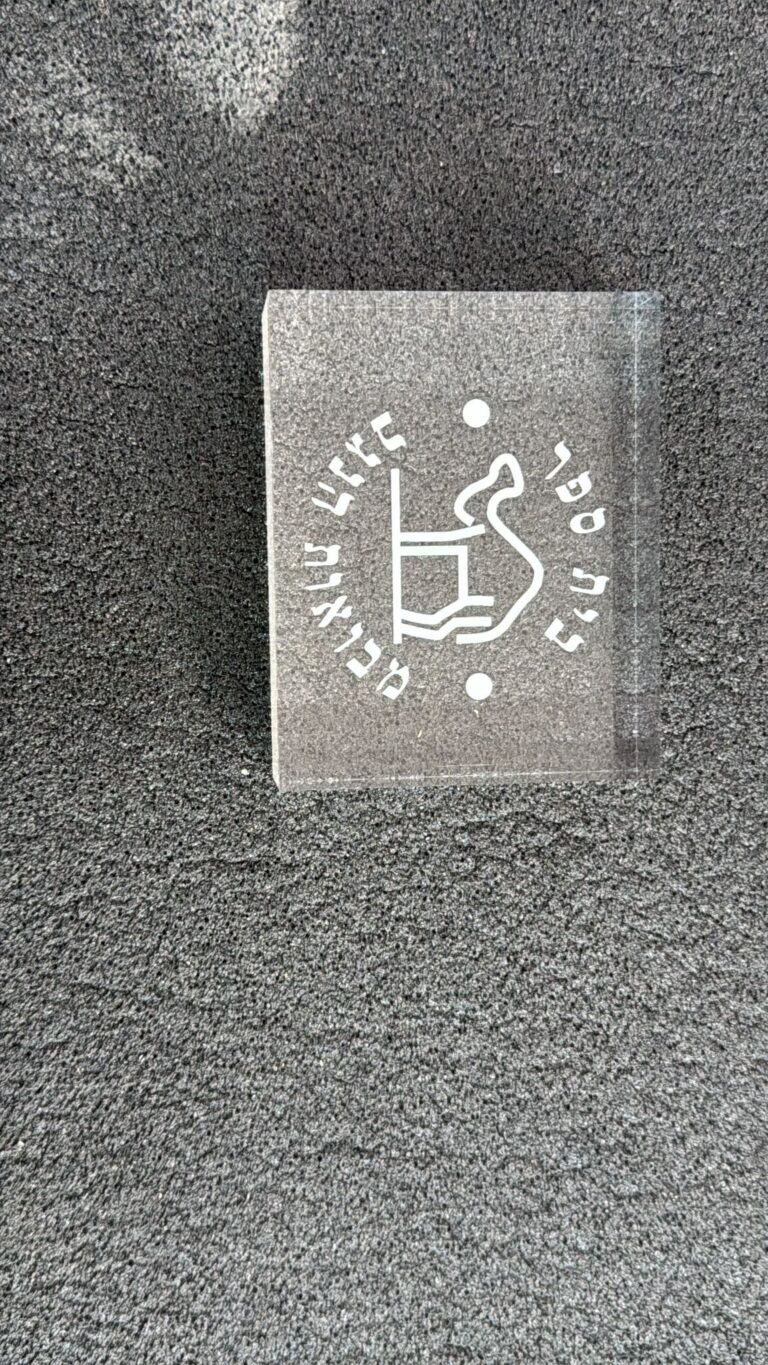 חריטה על בלוק פרספקס שקוף עם איור גמל ובית ספר מבואות הנגב