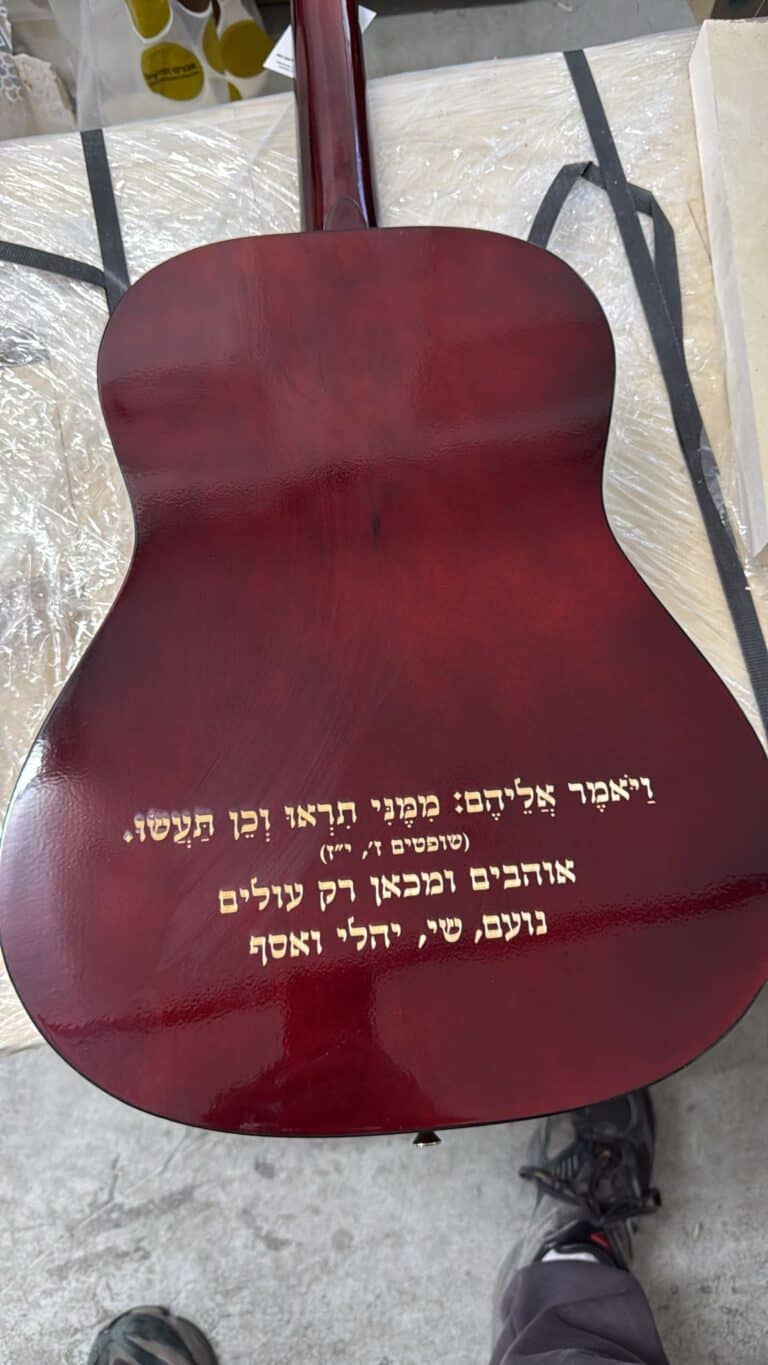 חריטה על גב גיטרה אוהבים ומכאן רק עולים