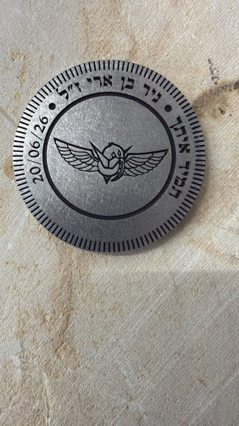 חריטה על גב מטבע מתכת להנצחת ניר בן ארי עם סמל יחידה מכונף והכיתוב תמיד איתך