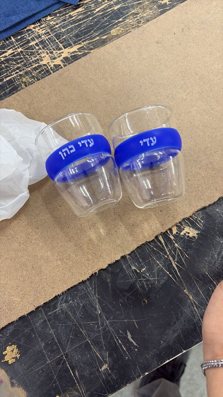 חריטה על זוג כוסות קפה פלסטיק עם חבק סיליקון כחול והשם עדי כהן