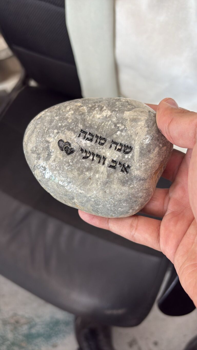 חריטה על חלוק נחל בברכת שנה טובה עם השמות איב ורועי ולבבות