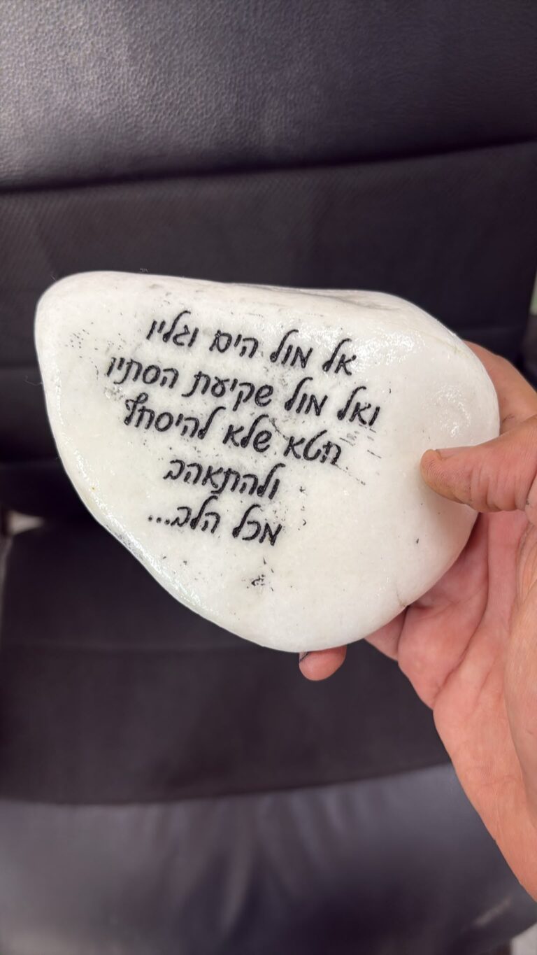 חריטה על חלוק נחל לבן עם השיר אל מול הים וגליו ואל מול שקיעת הסתיו