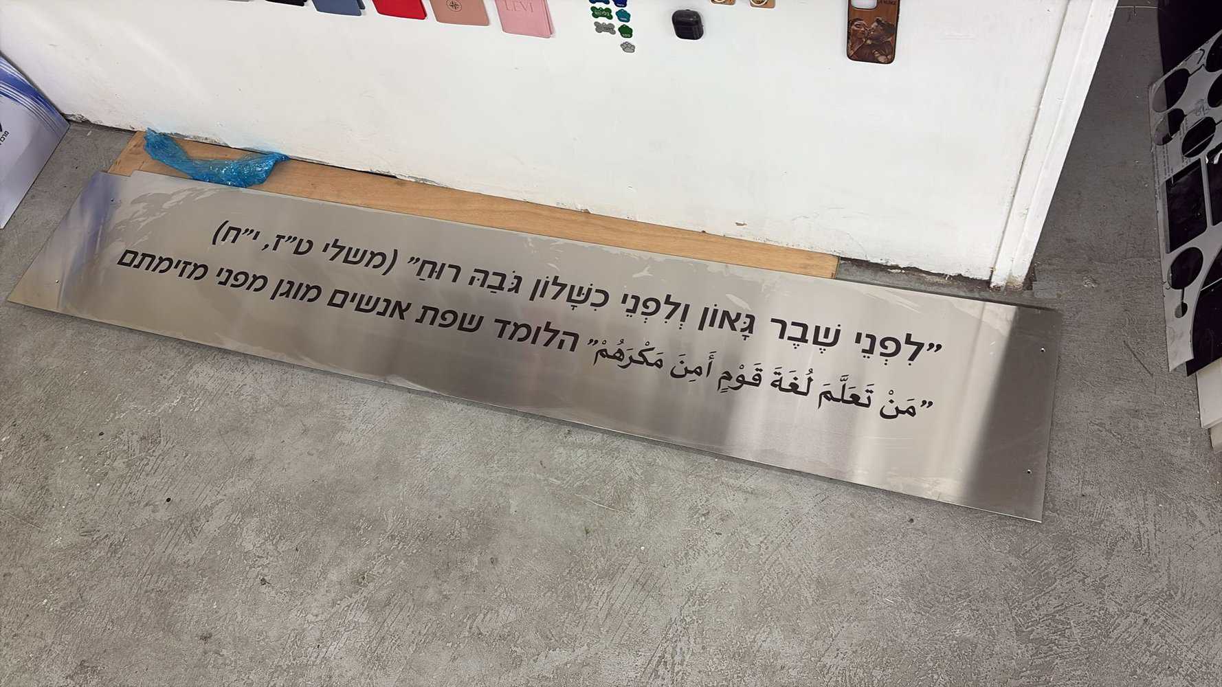 חריטה על לוח נירוסטה ענק עם חריטה בעברית וערבית