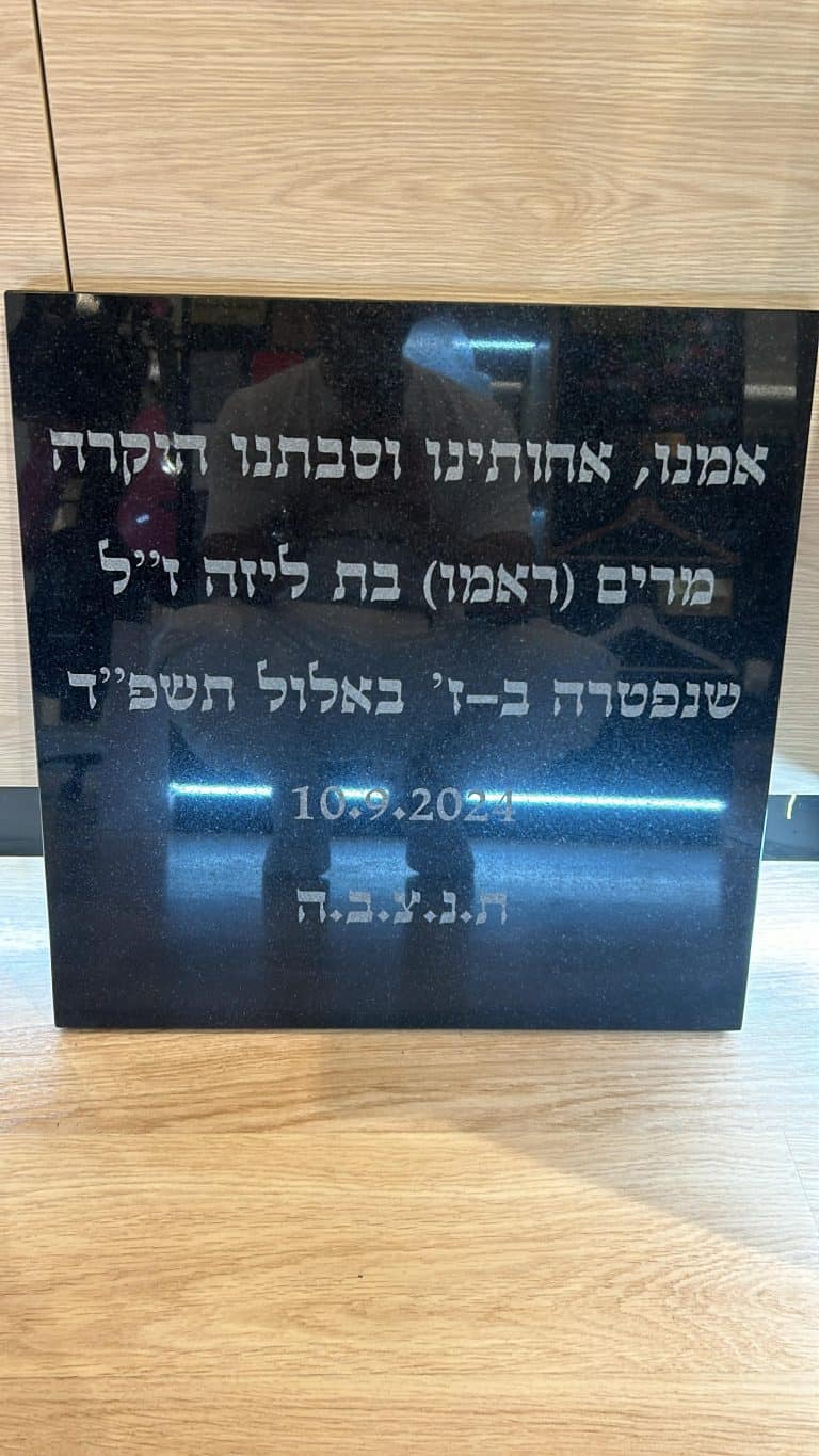 חריטה על לוח שיש להנצחה של אמנו