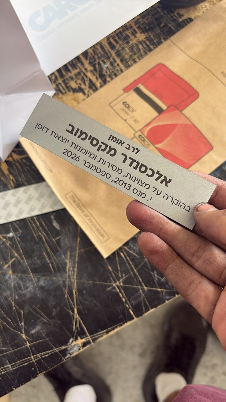 חריטה על לוחית כסופה בהוקרה לרב אומן אלכסנדר מקסימוב על מצוינות מסירות ומיומנות יוצאת דופן