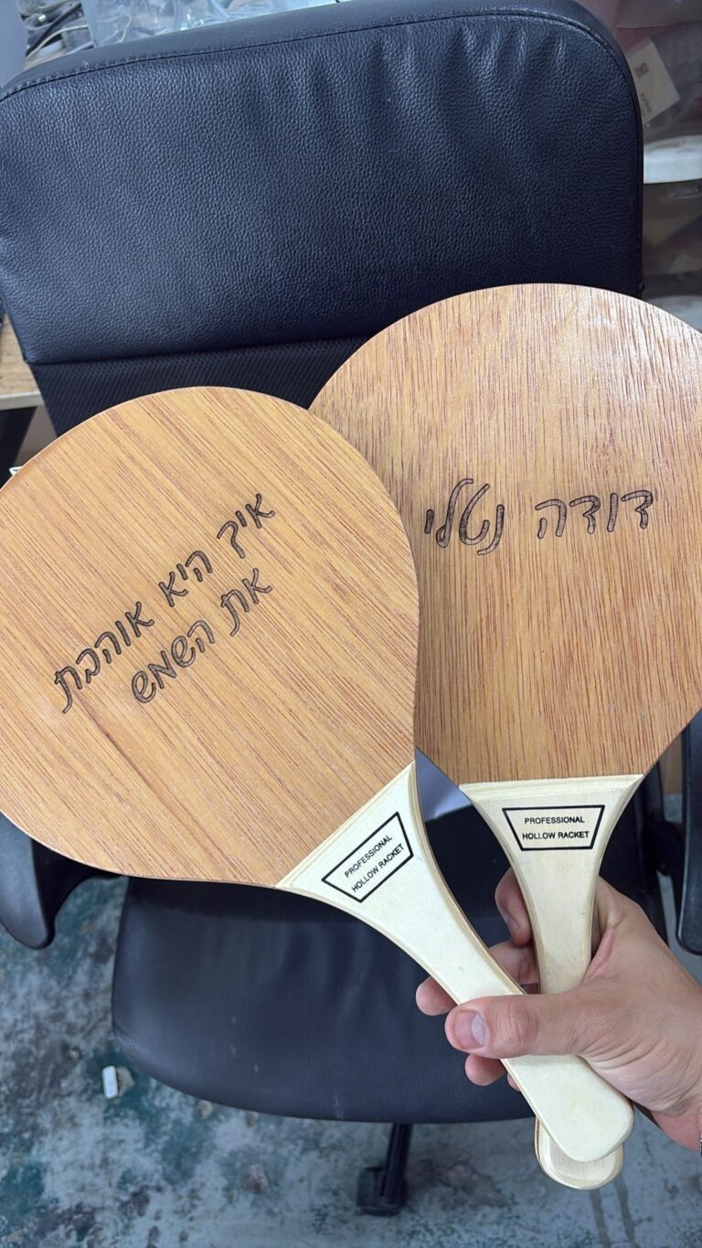 חריטה על מחבטי פינג פונג מעץ עם הכיתוב דודה נטלי ואיך קרא אוכל את העולם