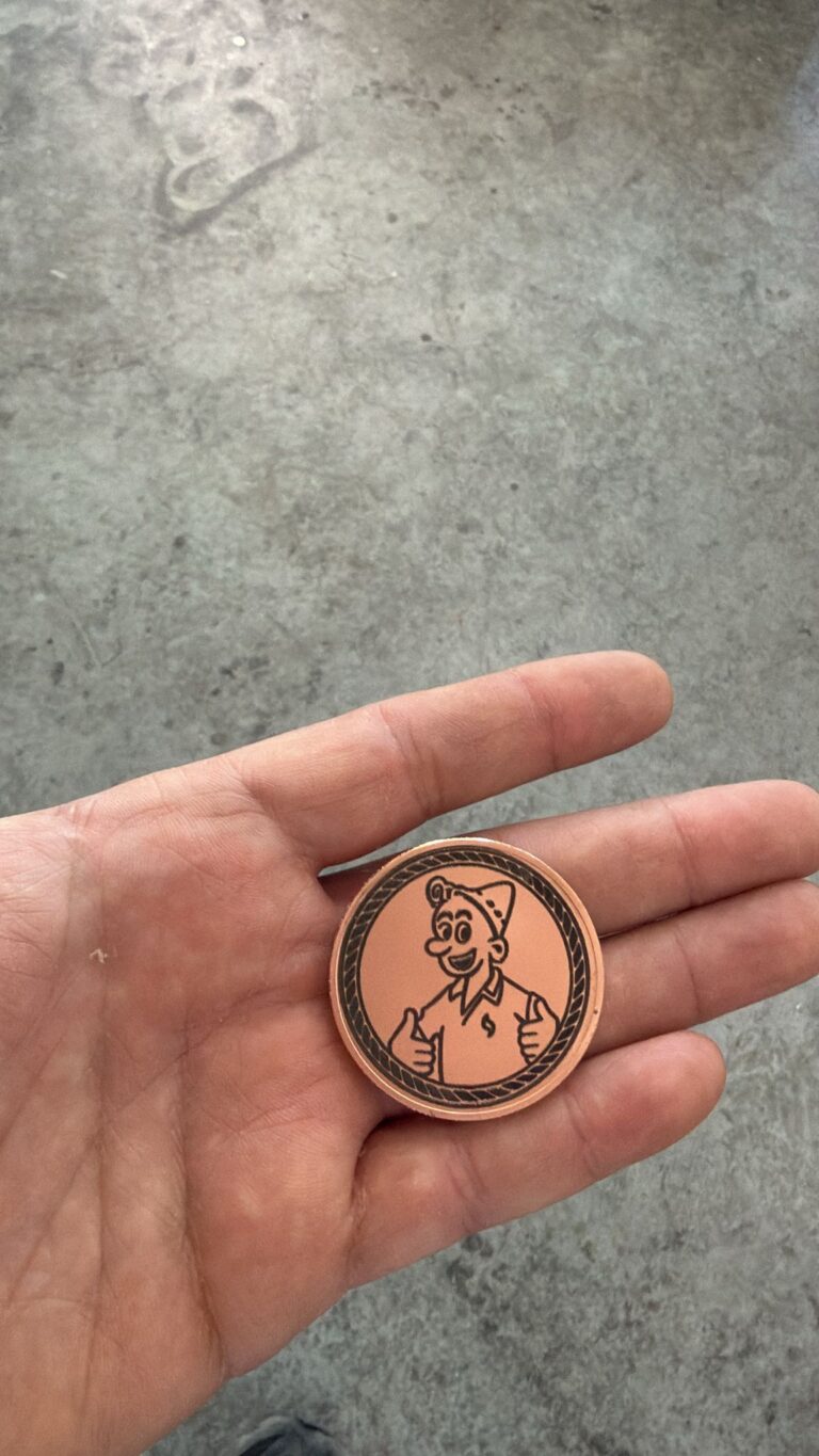 חריטה על מטבע מתכת נחושת עגול עם איור דמות מחייכת בכובע מרימה אגודלים