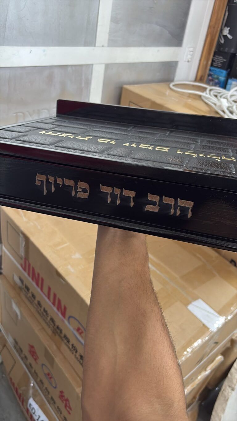 חריטה על סטנדר לסידור מעץ כהה עם אבני הכותל והשם הרב דוד פרייף