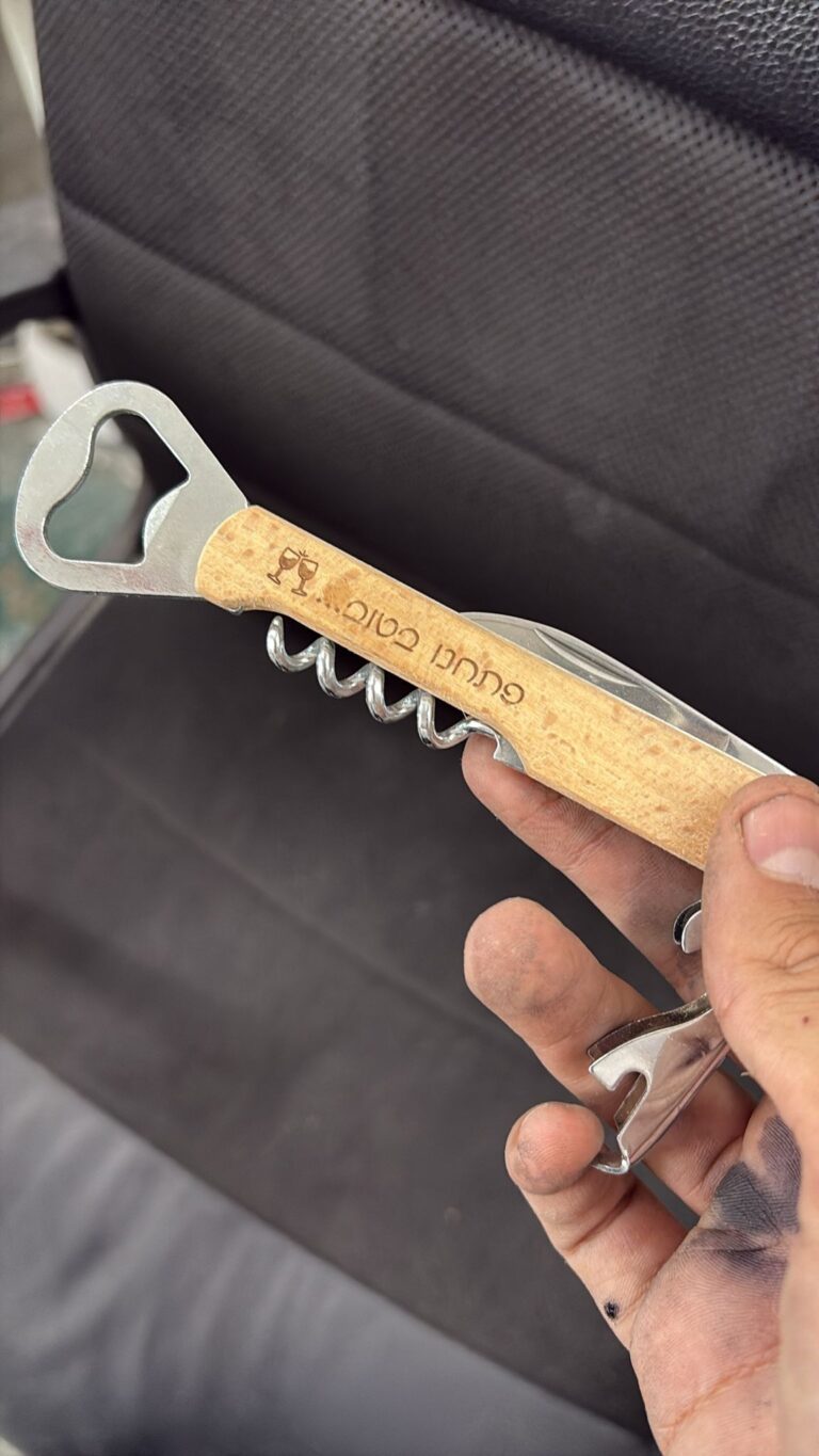 חריטה על פותחן יין מעץ מלצרי עם הכיתוב שמחה טובה ואיור כוסות