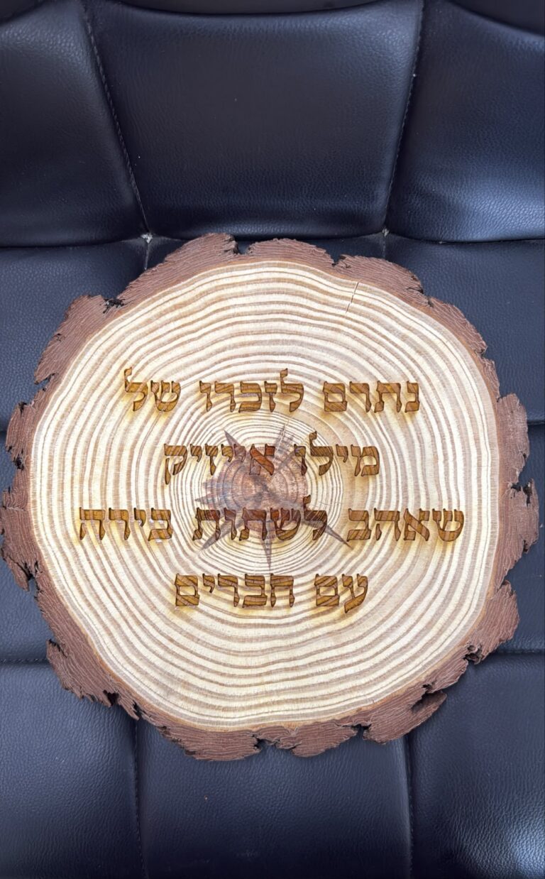 חריטה על פרוסת גזע עץ נתרם לזכרו של מילן איזיק שאהב לשתות בירה עם חברים