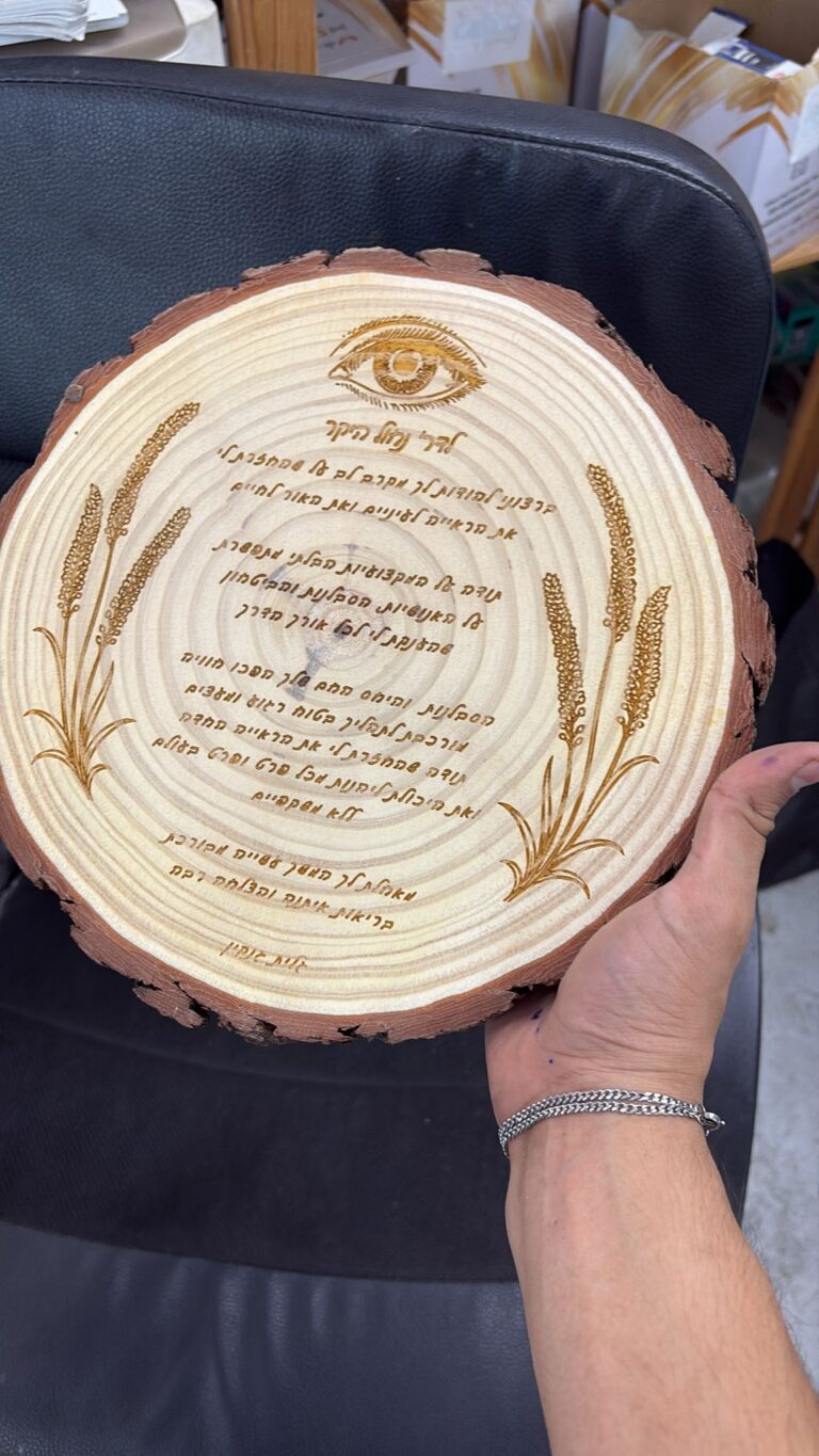 חריטה על פרוסת גזע עץ עם איור עין ושיבולים וטקסט הקדשה ארוך
