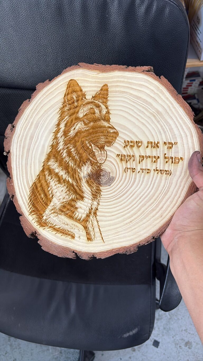 חריטה על פרוסת גזע עץ עם דיוקן כלב רועה גרמני והפסוק שבע יפול צדיק וקם