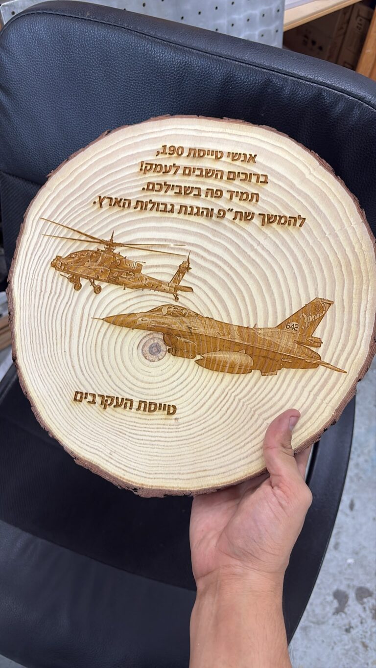 חריטה על פרוסת גזע עץ עם מטוס ומסוק לאנשי טייסת 190 העקרבים