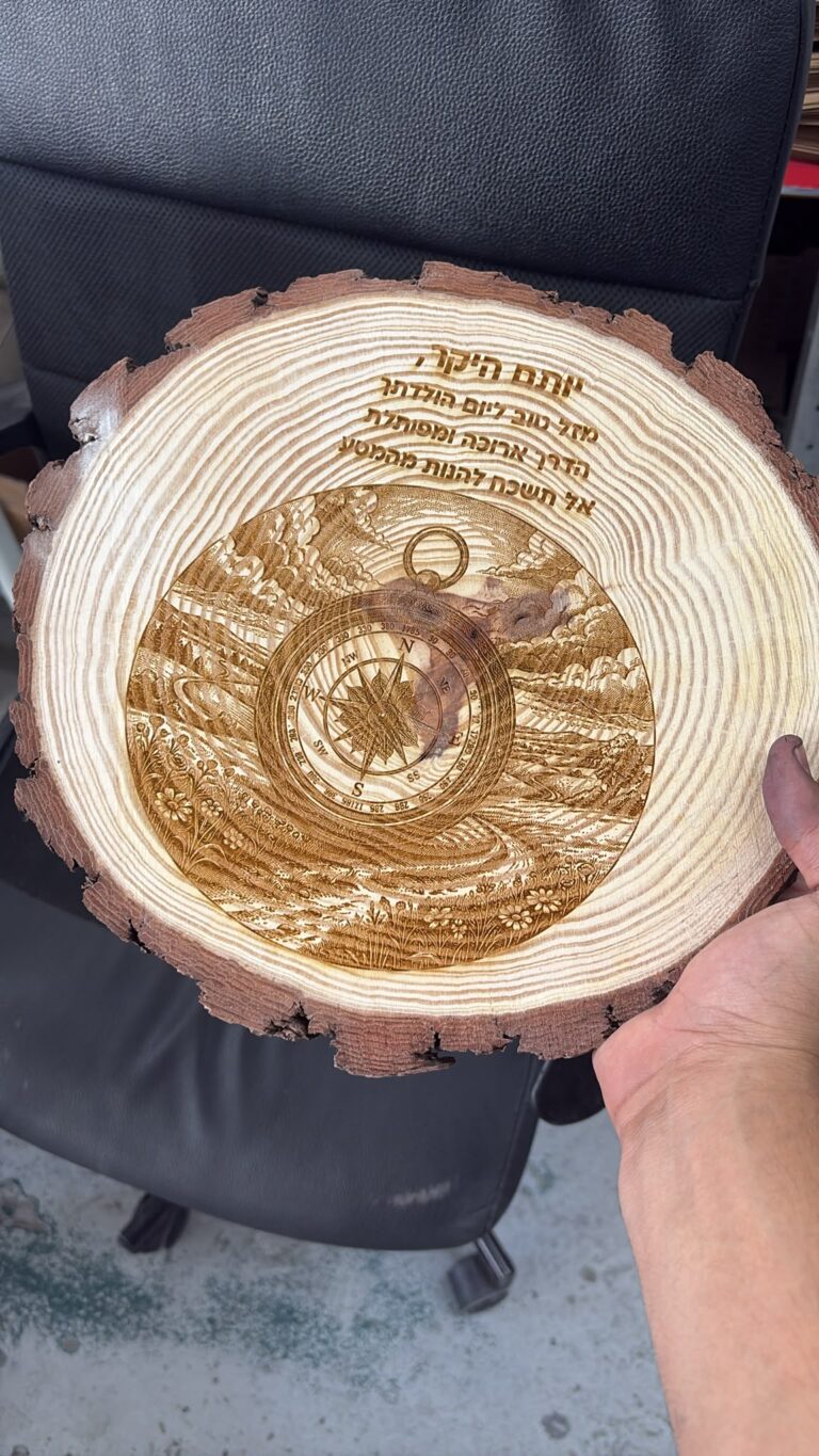 חריטה על פרוסת גזע עץ עם מצפן ונוף ליום הולדת יותם היקר אל תשכח להנות מהמסע