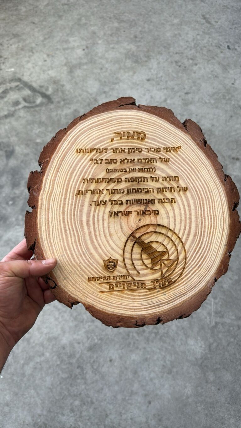 חריטה על פרוסת גזע עץ עם קליפה הקדשה למאיר ולוגו יחידת המשטח
