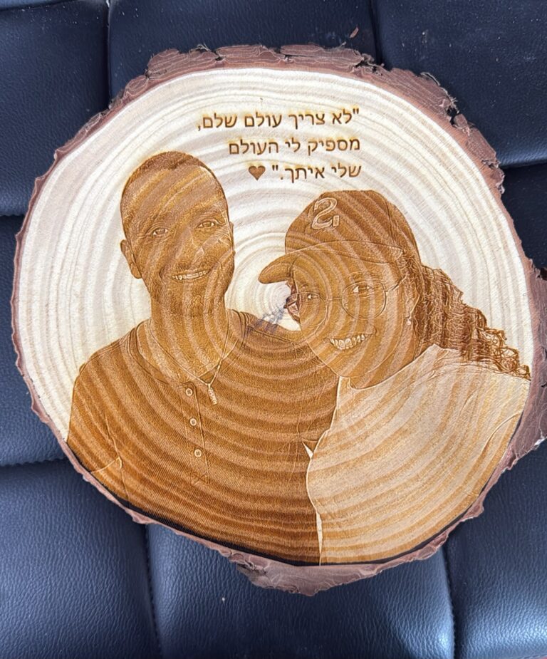 חריטה על פרוסת גזע עץ עם תמונת זוג והכיתוב לא צריך עולם שלם מספיק לי העולם שלי איתך