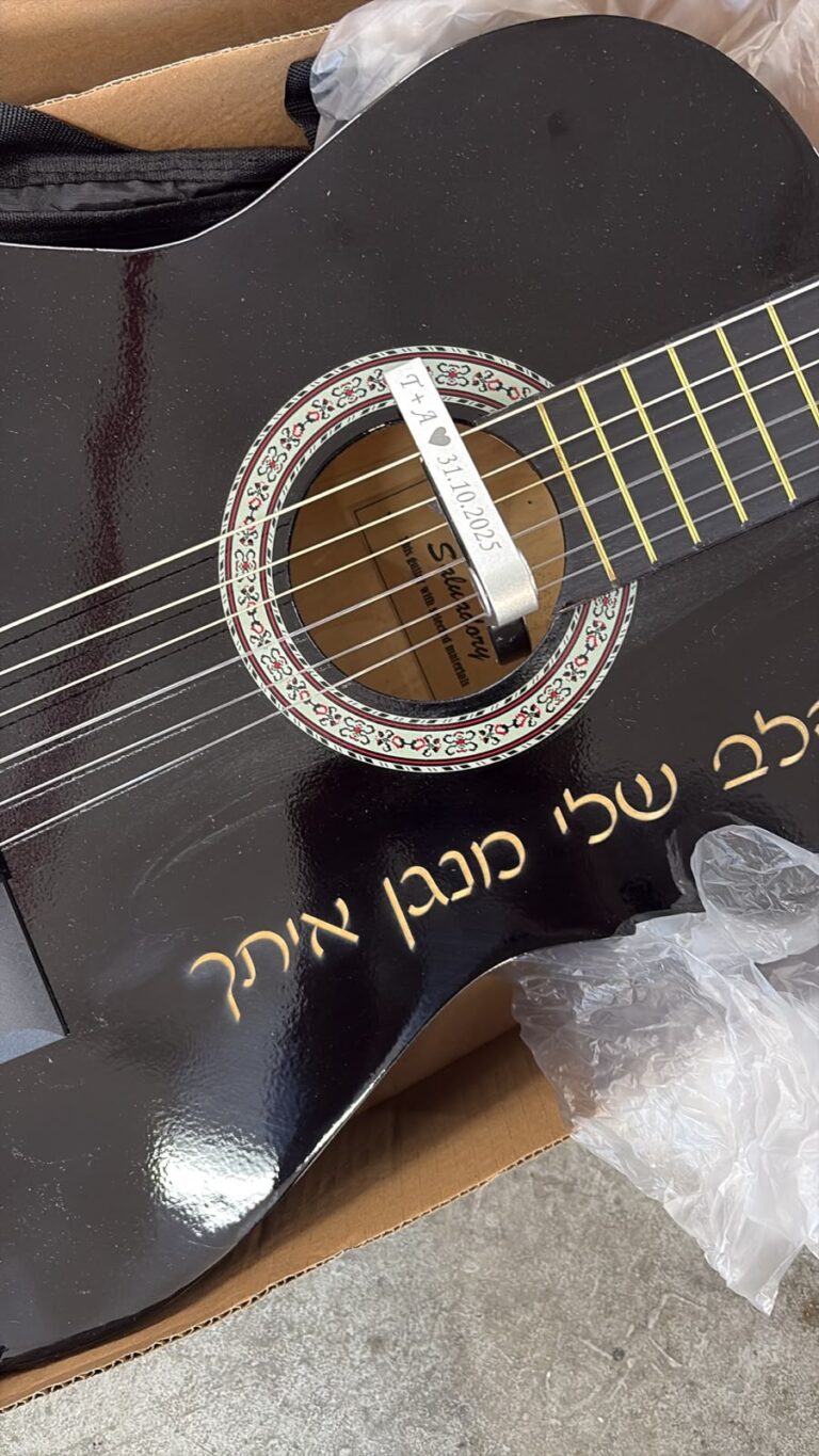 חריטה על קאפו לגיטרה מתכת עם לב ותאריך 31 10 2025 על גיטרה שחורה