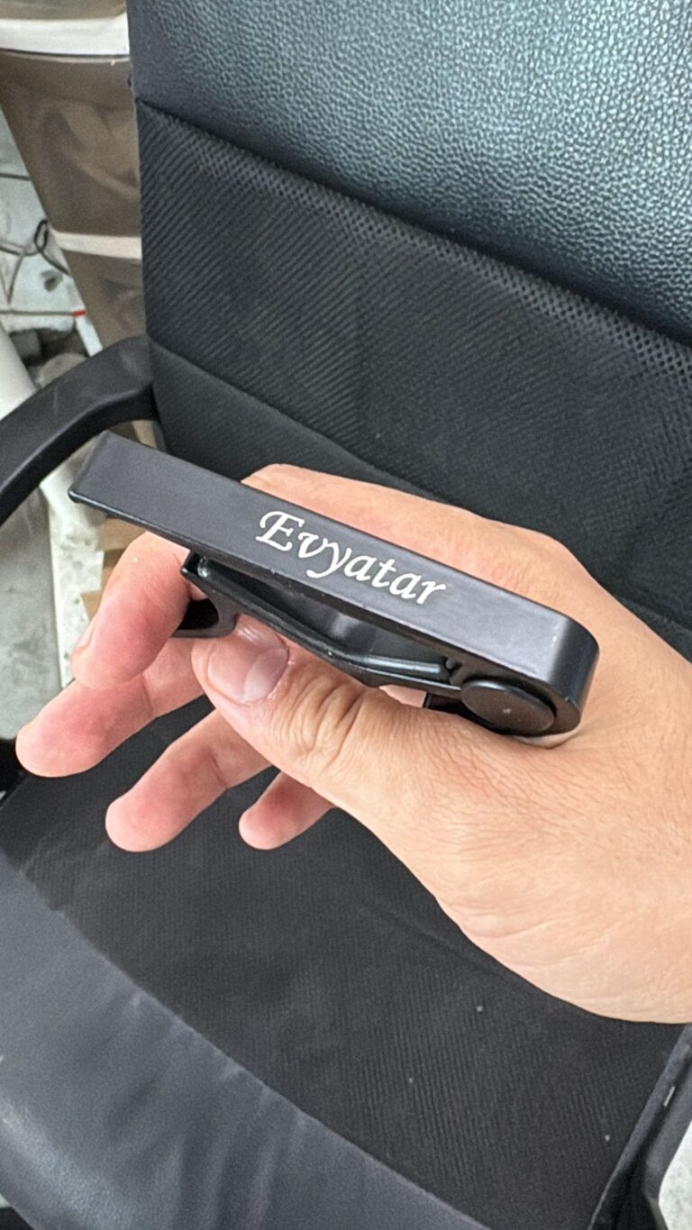 חריטה על קאפו לגיטרה מתכת שחור עם השם Evyatar