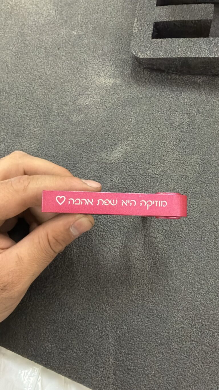 חריטה על קאפו לגיטרה צבעוני ורוד עם כיתוב מוזיקה היא שפת אהבה ולב