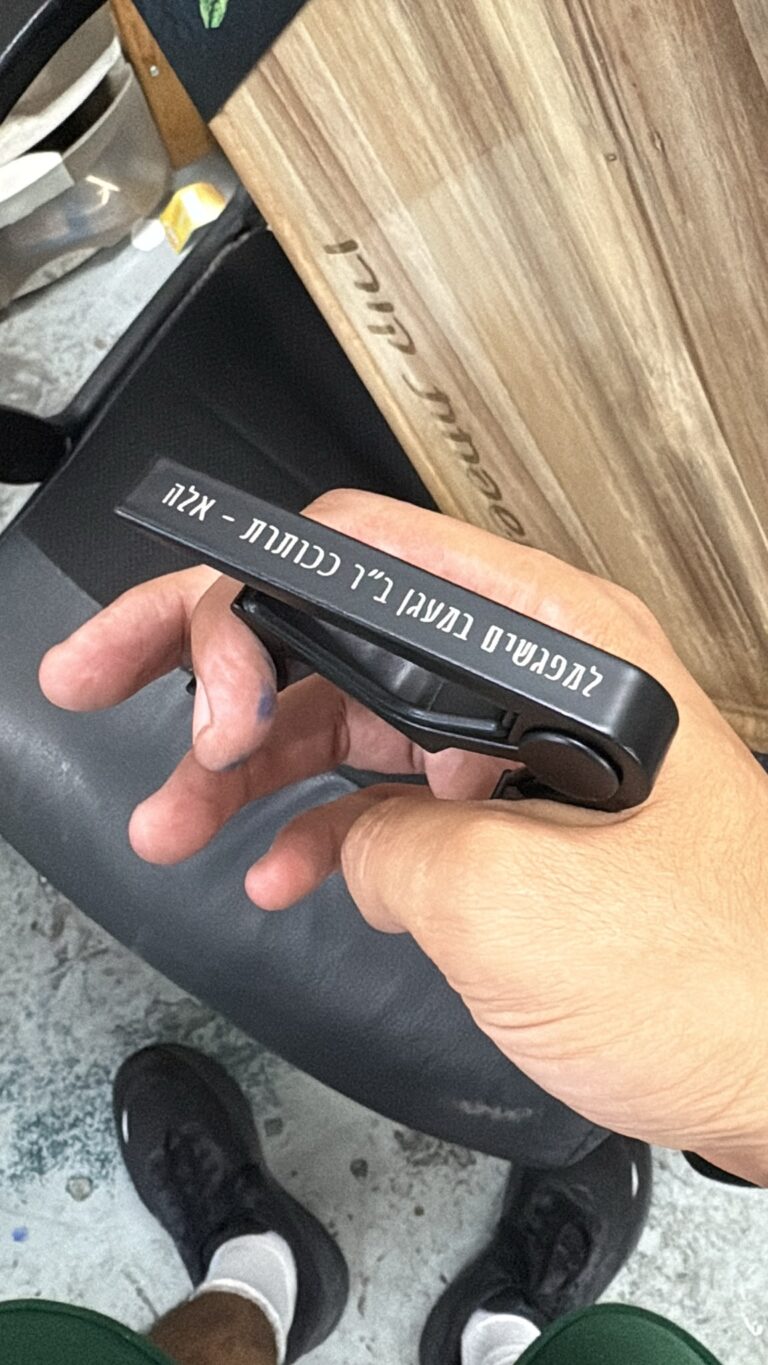 חריטה על קאפו לגיטרה שחור עם הקדשה למפגשים במעגן מאלה
