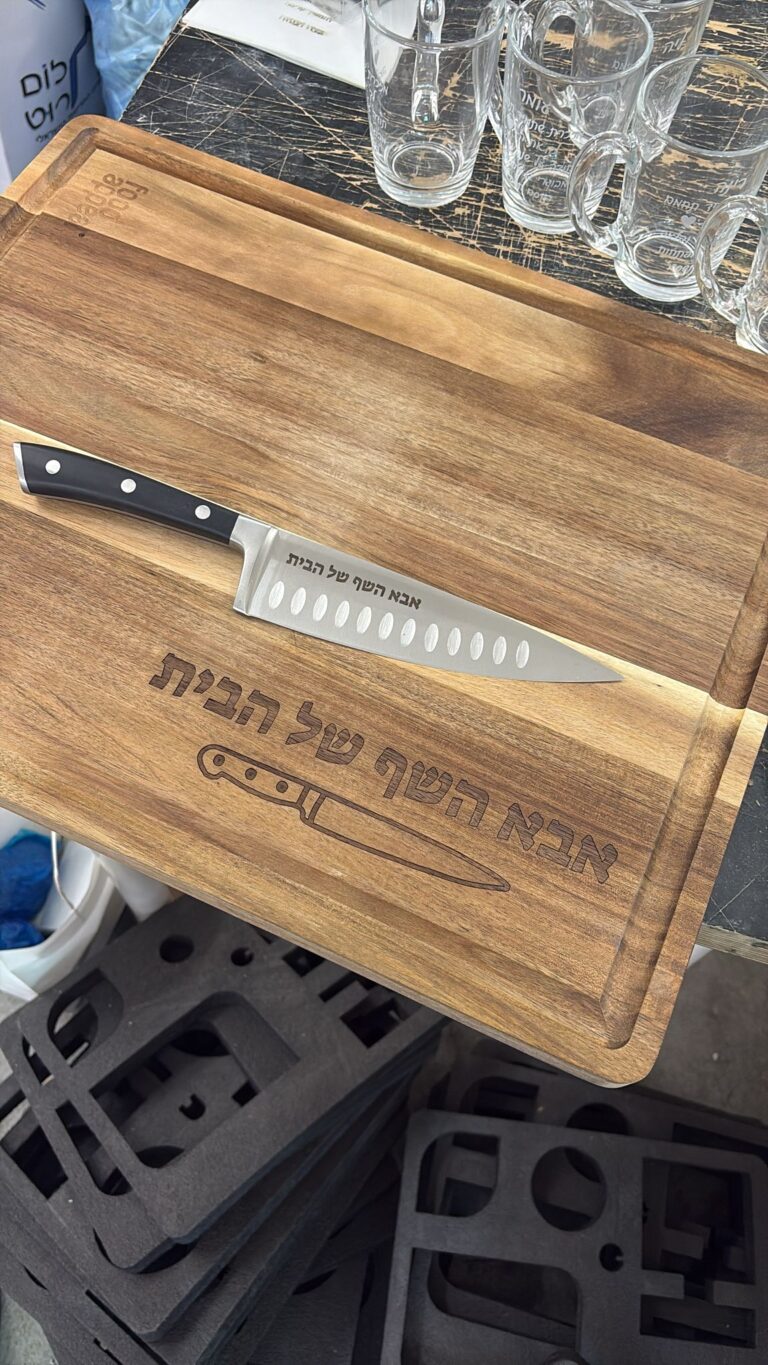חריטה על קרש חיתוך עץ אקציה וסכין שף עם הכיתוב אבא השף של הבית