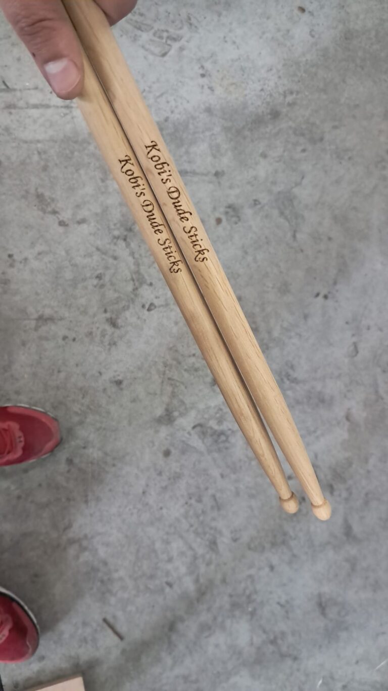 חריטה של Kobi's Dude Sticks על מקלות תופים מעץ