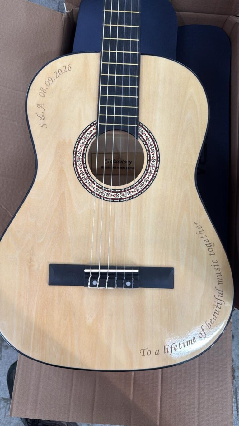 חריטה של S A 08 09 2026 ו To a lifetime of beautiful music together על גיטרה קלאסית עץ