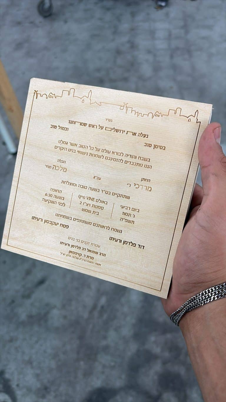 חריטה של הזמנה לחתונה על בלוק עץ ריבוע