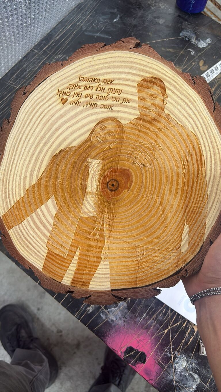 חריטה של זוג מחובק והקדשה אוהבת על פרוסת גזע עץ עם קליפה
