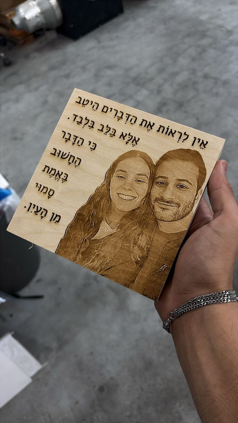 חריטה של זוג עם פתגם על בלוק עץ מרובע