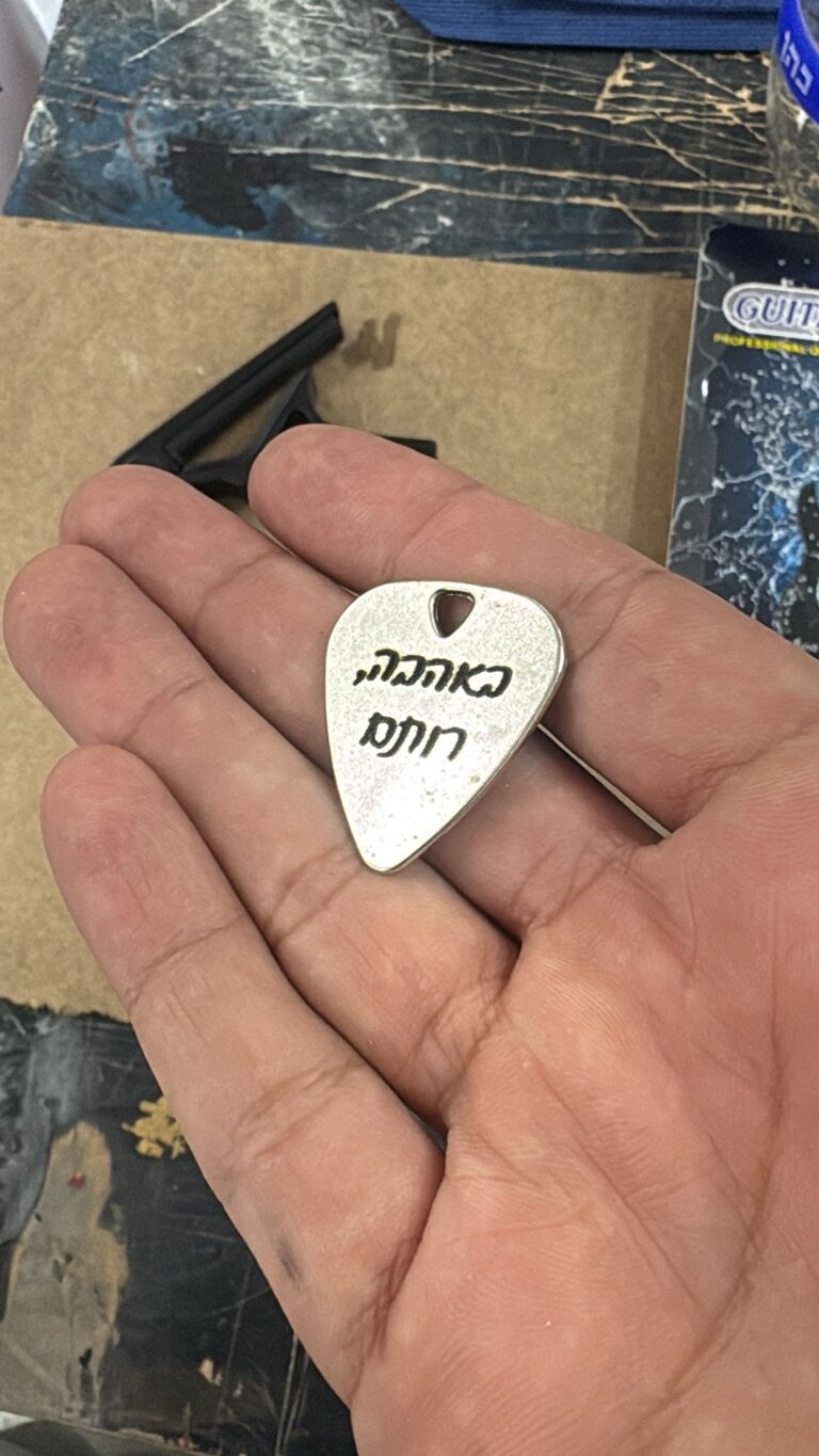 חריטה של כיתוב באהבה רותם על מפרט גיטרה מתכת