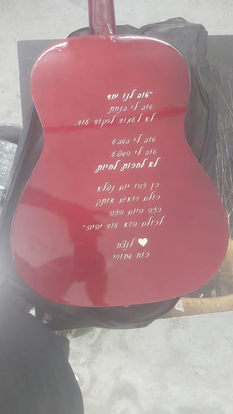 חריטה של כתב יד על גב גיטרה