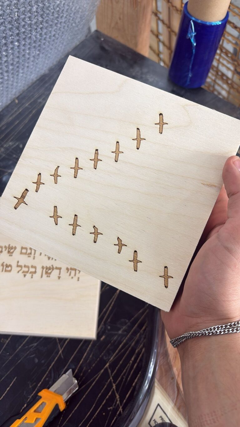 חריטה של להקת ציפורים מעופפות על בלוק עץ