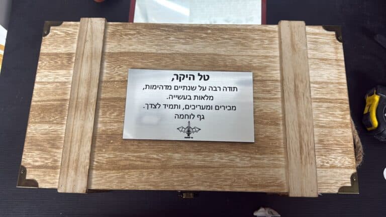 לוחית פלסטיק כסופה עם הקדשה מודבקת על גבי עץ
