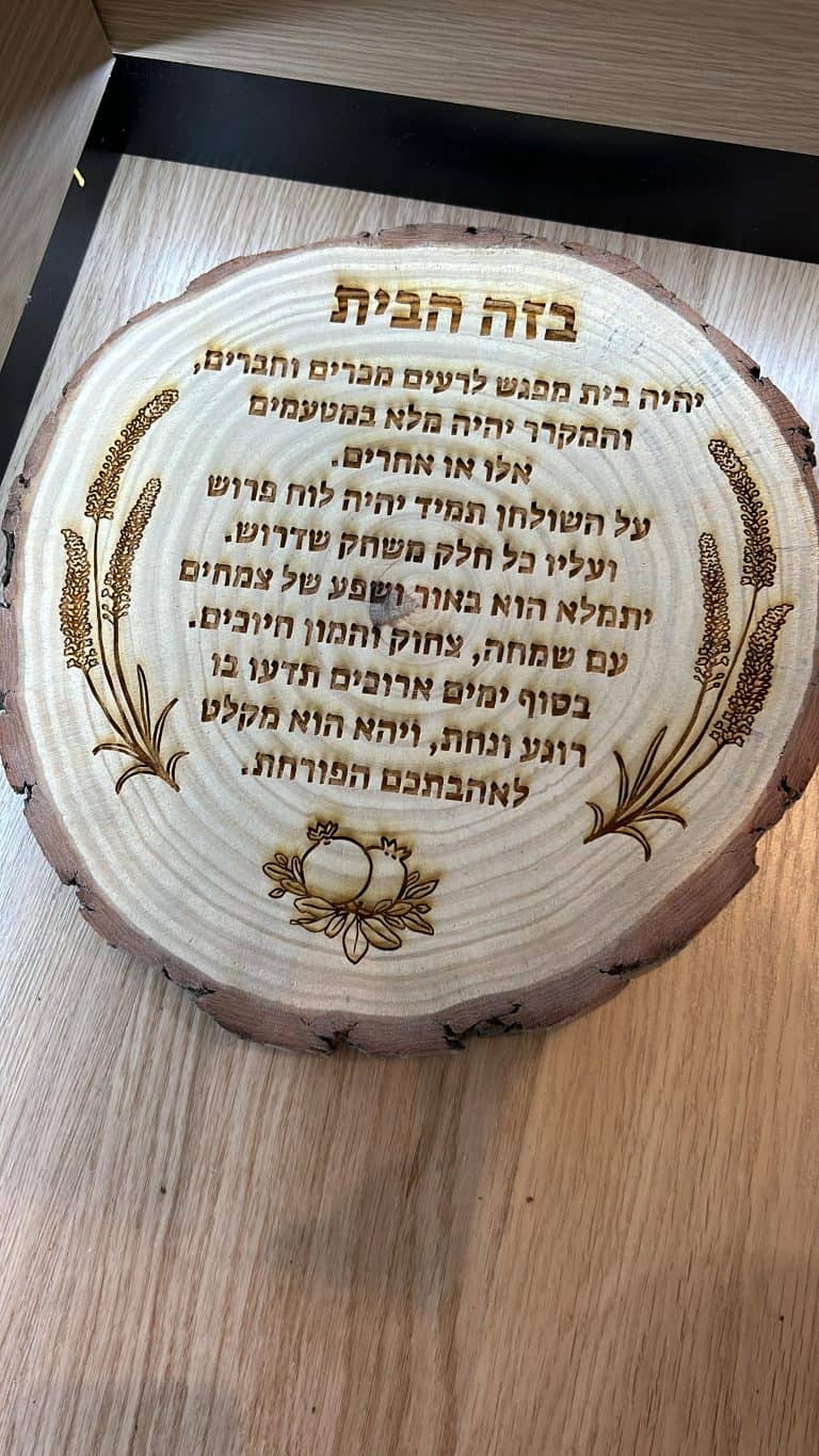 פרוסת גזע עץ עם חריטה ברכת הבית