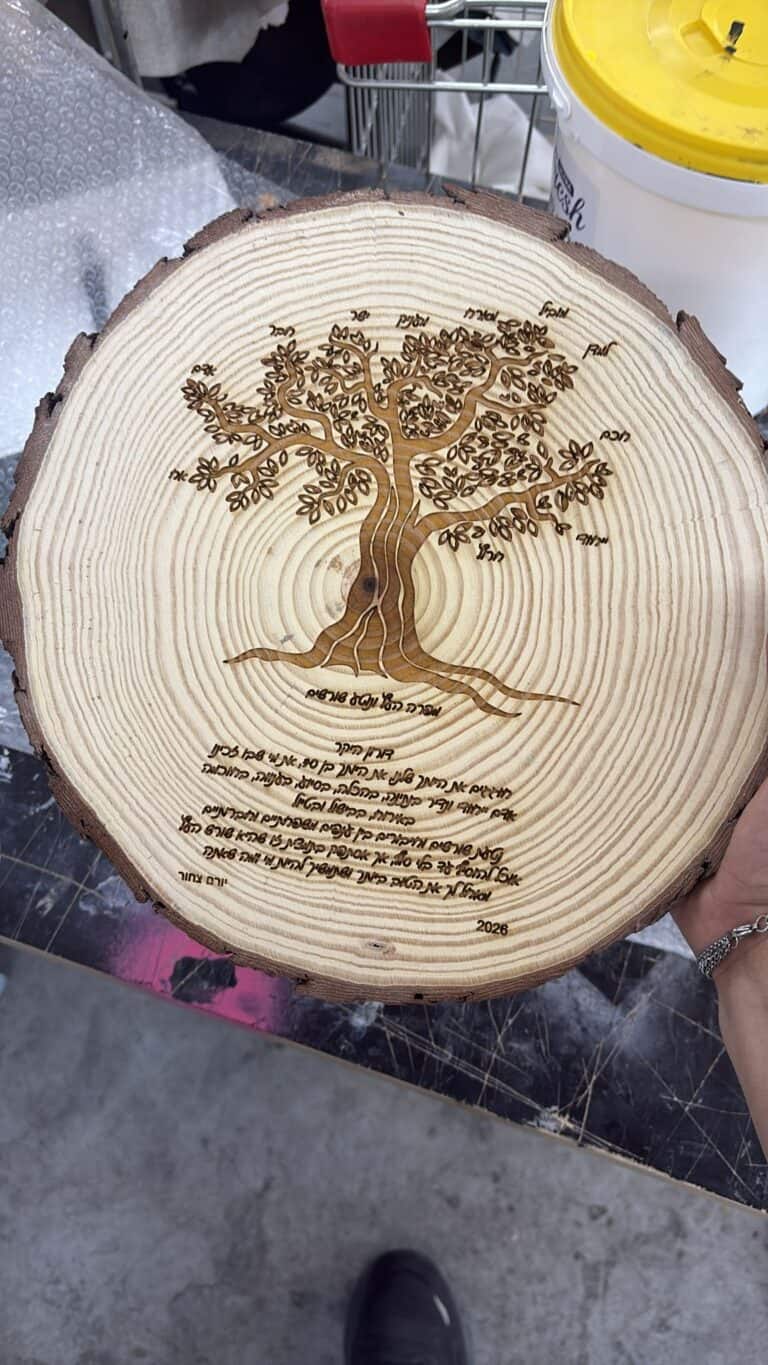 ציור עץ ועלים עם ברכה על פרוסת גזע